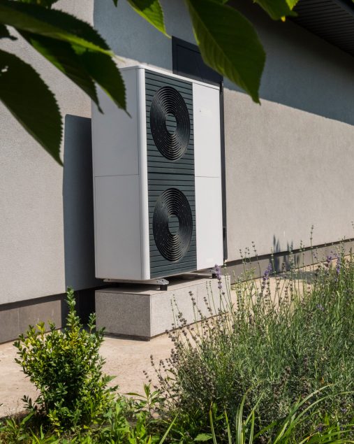 External heat pump unit against the wall of the house. Modern technologies for energy saving.