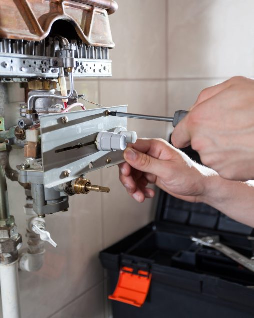 Tightening bolt on gas water heater using screwdriver